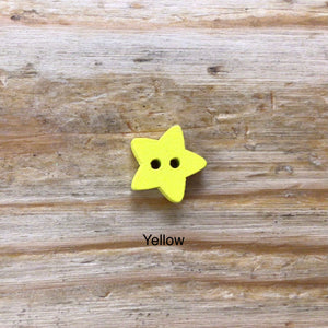 small wooden star buttons painted in different colours on wooden surface