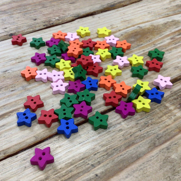 small wooden star buttons painted in different colours on wooden surface